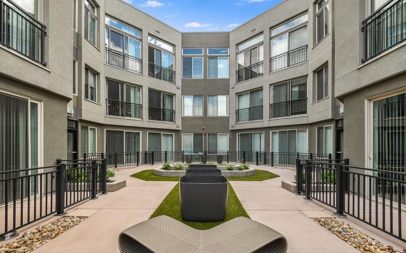 a patio with a table and chairs in front of a building