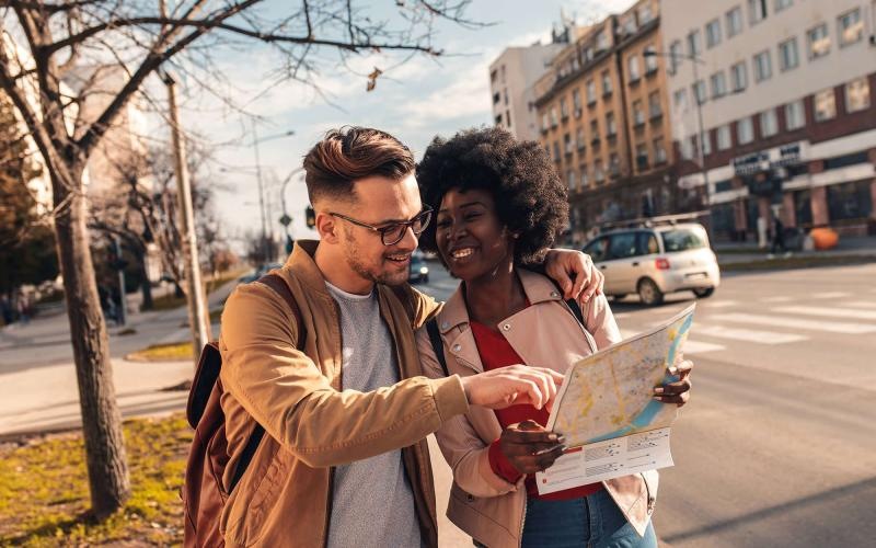 a man and woman looking at a map in the city
